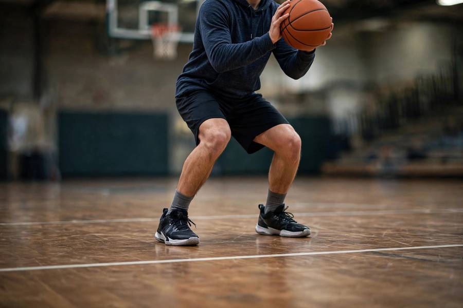 Photorealistic image showing balanced shooting stance with feet positioned, court floor view