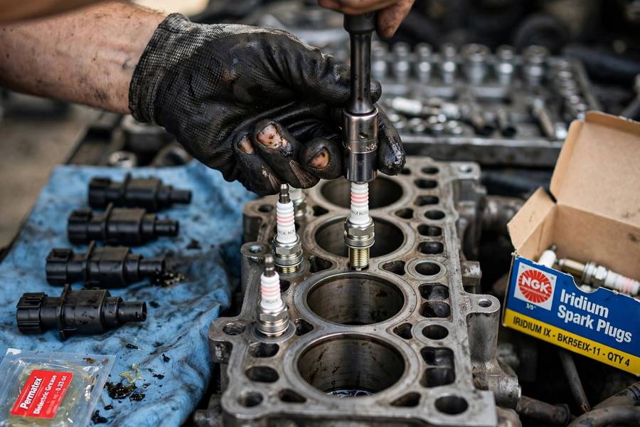 Mechanic replacing all spark plugs at once in an engine