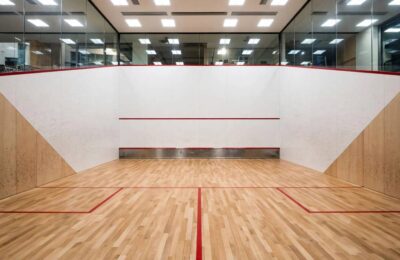 Interior of a standard squash court showing official dimensions, front wall, and floor markings