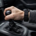 Symptoms of Dirty Transmission Fluid: 9 Signs Your Fluid Is Spent Driver's hand on a gear shifter during rough shifting