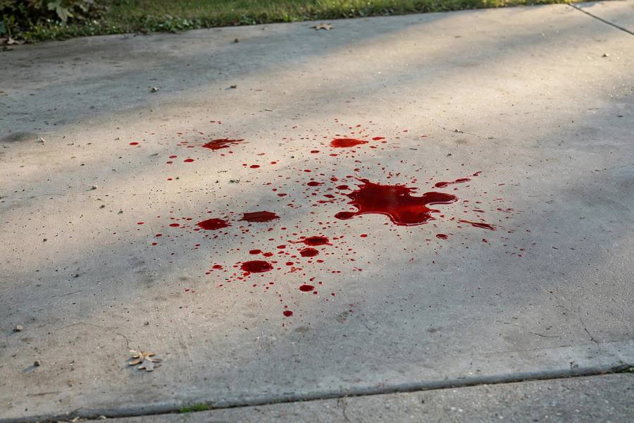Red fluid spots on a driveway indicating a transmission fluid leak
