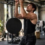 Weighted Pull-Ups: The Complete Guide to Building Serious Pulling Strength Athlete performing weighted pull-up with dip belt and weight plate in a gym