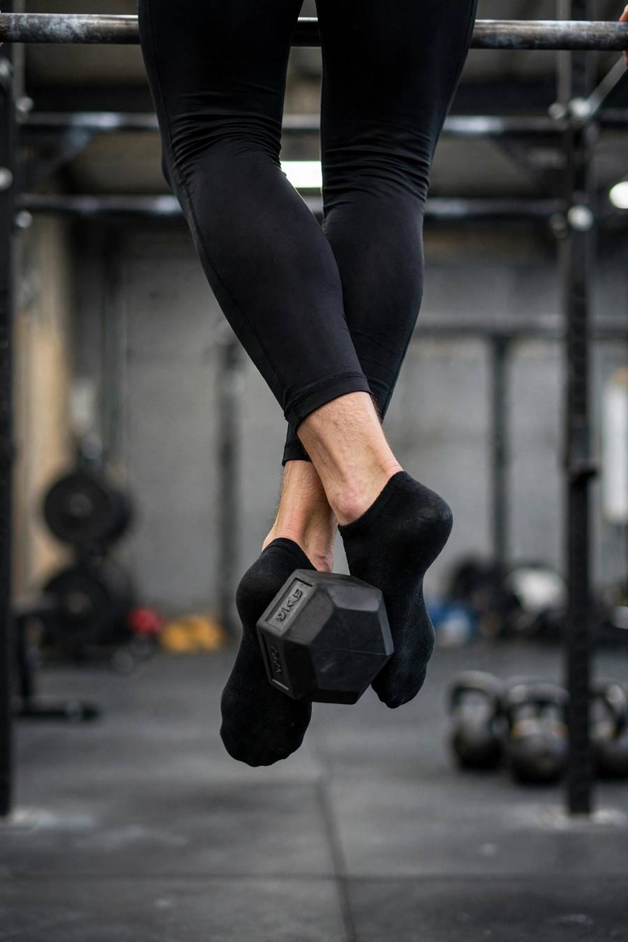 Dumbbell held between crossed feet as an alternative weighted pull-up method