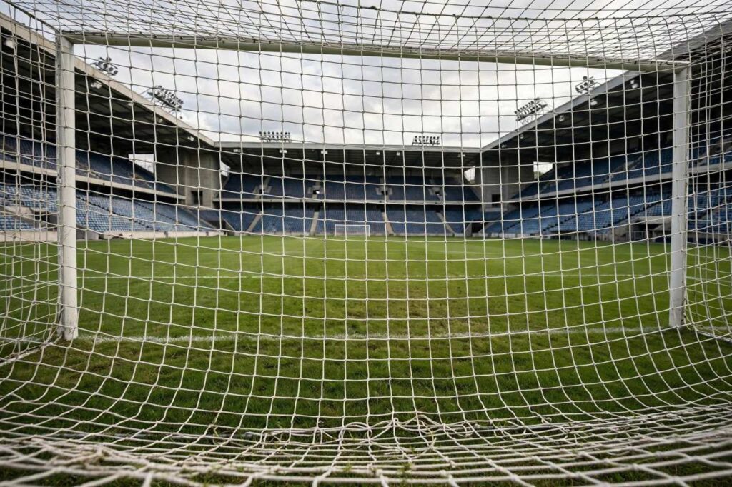 Soccer goal with net from behind at an empty stadium, no people