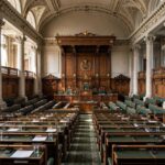 What Is a Parliamentary System? How It Works Interior of a grand parliament chamber with rows of seats and ornate architecture