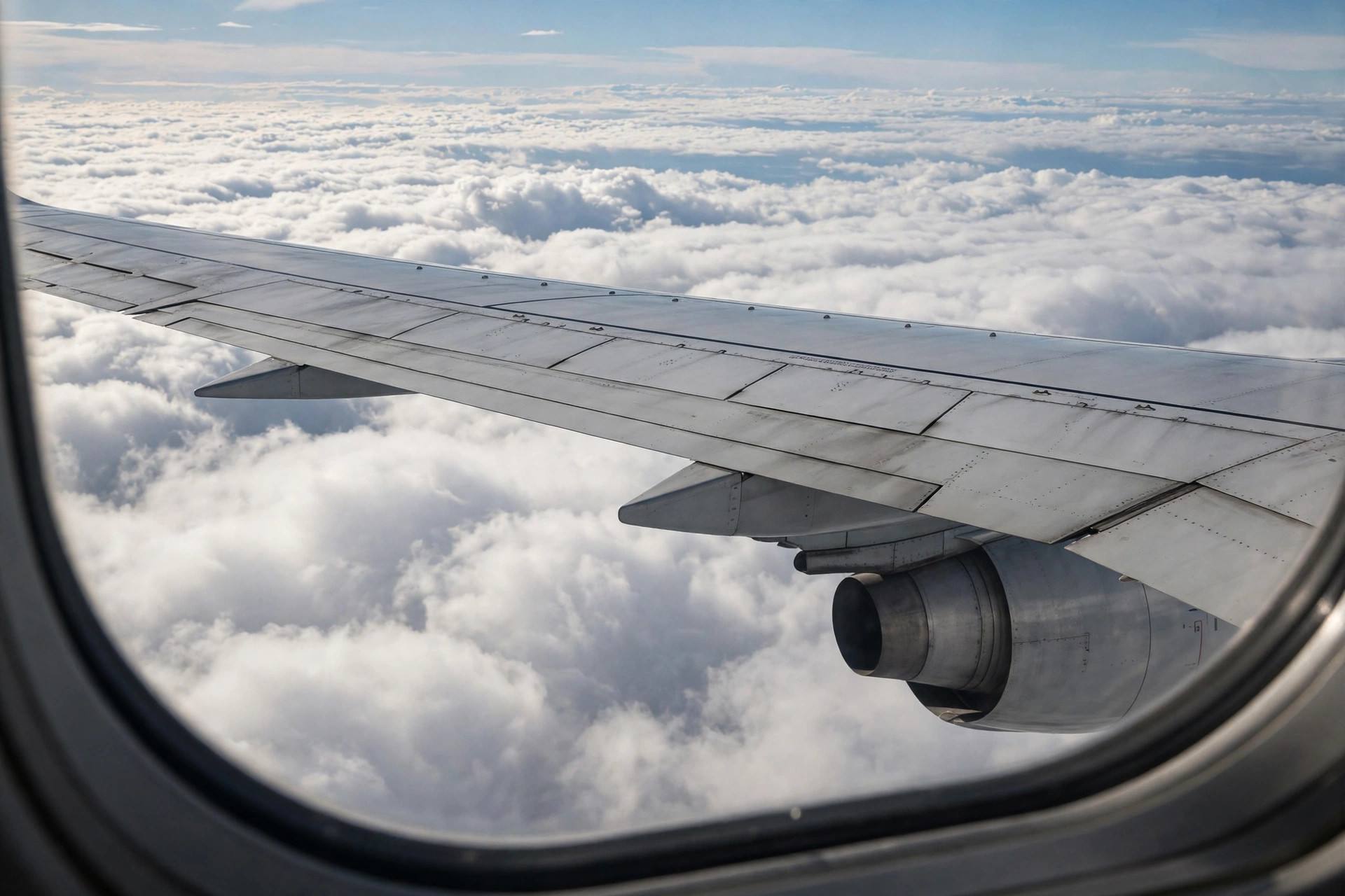 Airplane wing above clouds during international flight