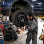 What Is Tire Rotation? Why It Matters and When to Do It Mechanic rotating tires on a car lifted in a garage