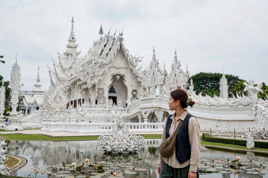 Wat Rong Khun white temple with visitor in modest dress