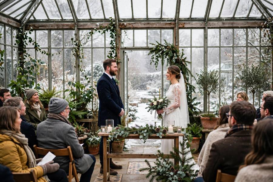 A conservatory winter wedding with snow falling outside — magical winter wedding ideas for cold-weather celebrations